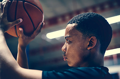 An African American child shoots a basketball