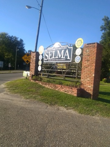 Blue sign with white writing held up with brick pillars. Says "Welcome to historic Selma."