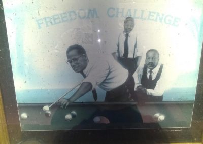 A poster of three men playing pool. Says "Freedom Challenge."
