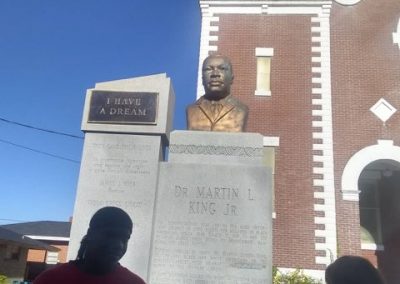 A bust of Dr. Martin Luther King Jr. on a stone stand engraved with his "I Have a Dream" speech.