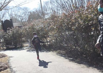 A boy running along a paved path.