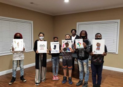 Seven children and adults showing their artwork related to African American culture